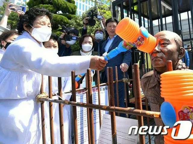 27日、韓国光州の裁判所の前で全斗煥氏のひざまづいた銅像を叩く市民（提供:news1）