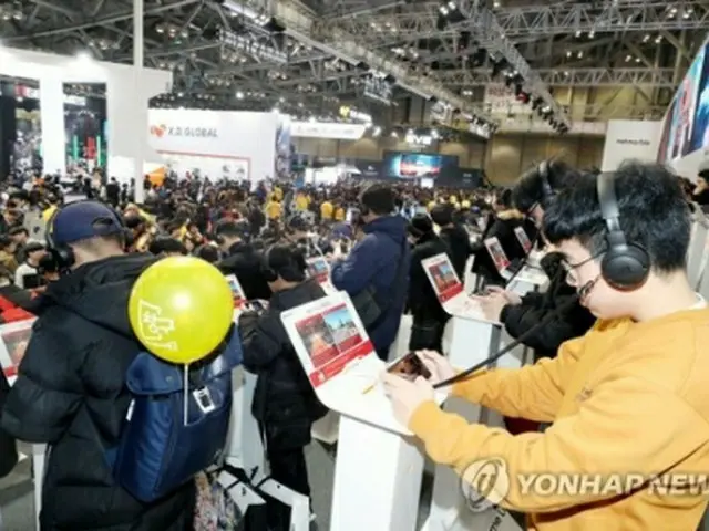 昨年11月に釜山で開催された韓国最大規模のゲーム展示会「G－STAR2019」の会場でモバイルゲームを楽しむ来場者（資料写真）＝（聯合ニュース）
