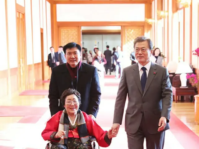 韓国の文在寅大統領が2018年初め大統領府で、元慰安婦の李容洙氏の手をとって歩いている（提供:news1）