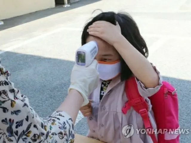 韓国で首都圏を中心に新型コロナウイルスの感染拡大が続くなか、南西部・光州市の小学校で登校した児童が体温チェックを受けている（資料写真）＝（??聯合ニュース）