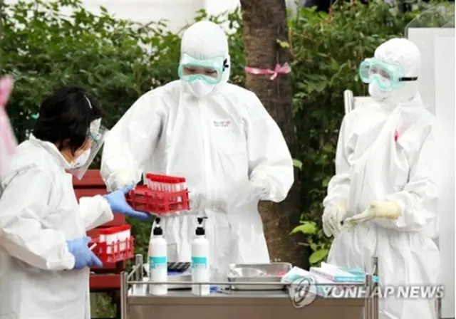 京畿道富川市の保健所に設けられた専用診療所で検査を行う医療従事者ら（資料写真）＝（聯合ニュース）