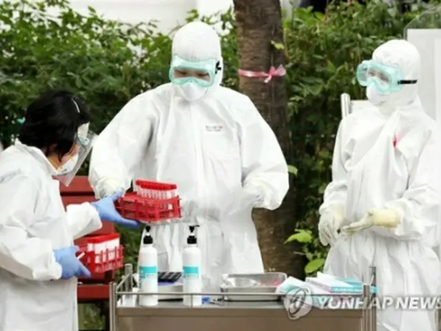 京畿道富川市の保健所に設けられた専用診療所で検査を行う医療従事者ら（資料写真）＝（聯合ニュース）