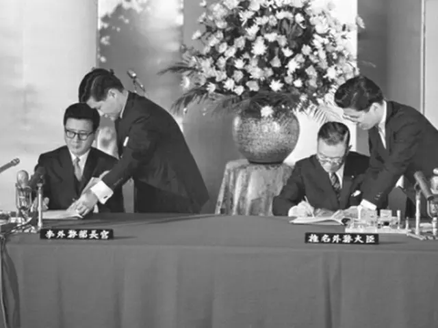 1965年6月22日、東京で基本条約に署名する李東元（イ・ドンウォン）外務部長官（左）と椎名悦三郎外相＝（共同＝聯合ニュース）