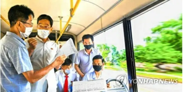 バスで朝鮮労働党機関紙、労働新聞を読む北朝鮮住民（同紙HPより）＝（聯合ニュース）≪転載・転用禁止≫