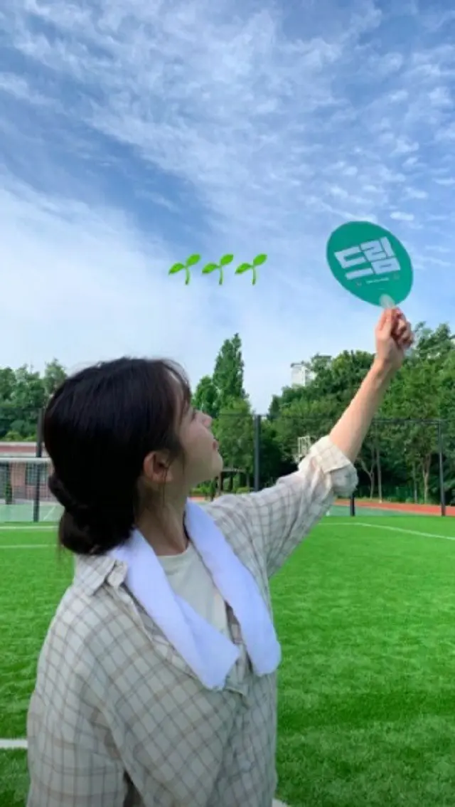 IU、映画「ドリーム」のうちわを持った写真を公開…チェックシャツを着てもかわいさ爆発