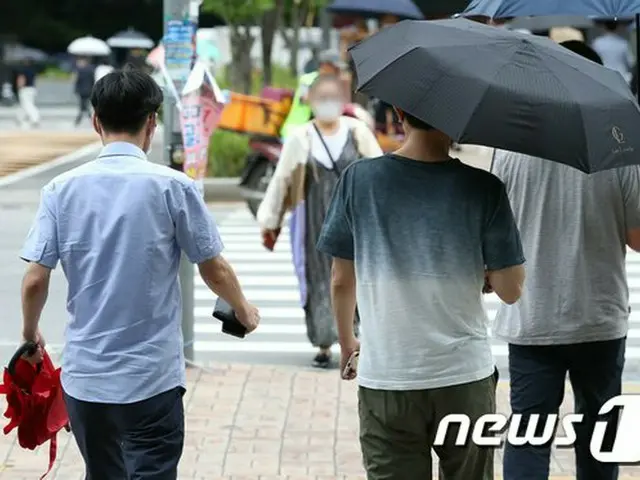 先月30日午後、ソウル市内で市民たちが傘を持ち、通りを歩いている（提供:news1）