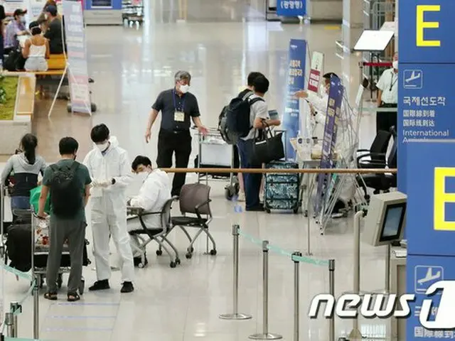 韓国 仁川空港で海外入国者が医療陣から質問を受けている（提供:news1）