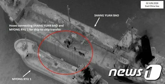 東シナ海の海上で、パナマ船籍の貨物船から北朝鮮の船にホースで石油製品が移されている（提供:news1）
