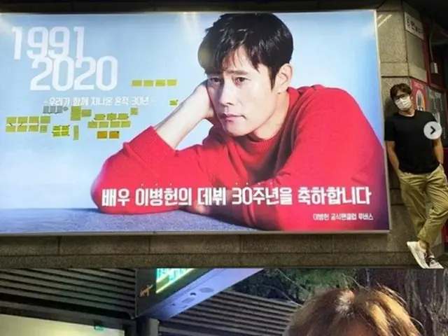 俳優イ・ビョンホン、デビュー30周年を祝う地下鉄広告の前で認証ショット“ファンのサポートに感謝”(提供:news1)