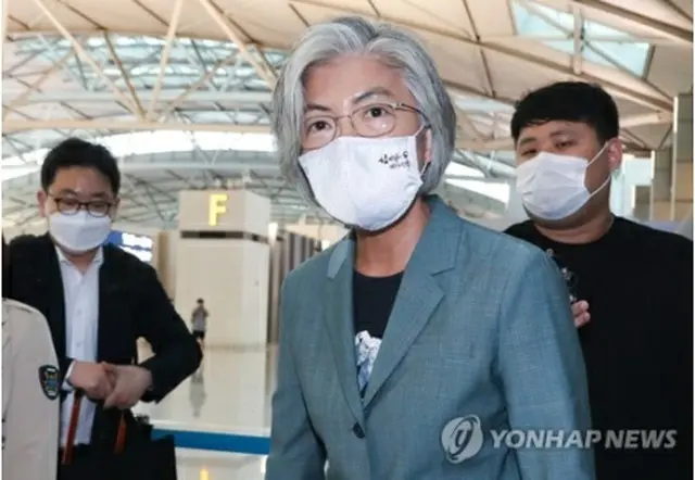 仁川空港で記者団に囲まれる康長官＝９日、仁川（聯合ニュース）