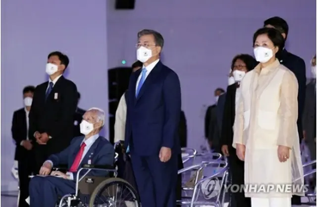 記念式典で国歌を歌う文在寅大統領夫妻＝１５日、ソウル（聯合ニュース）