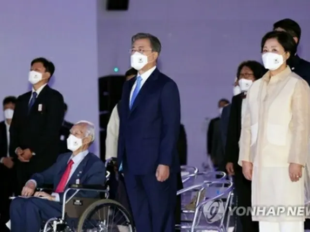 記念式典で国歌を歌う文在寅大統領夫妻＝１５日、ソウル（聯合ニュース）