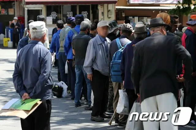 韓国ソウルの公園付近で、無料の食事を受け取るために高齢者たちが並んでいる（画像提供:wowkorea）