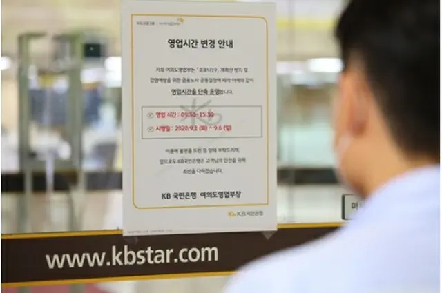 営業時間の短縮を知らせる案内文が貼られているＫＢ国民銀行の店舗＝１日、ソウル（聯合ニュース）