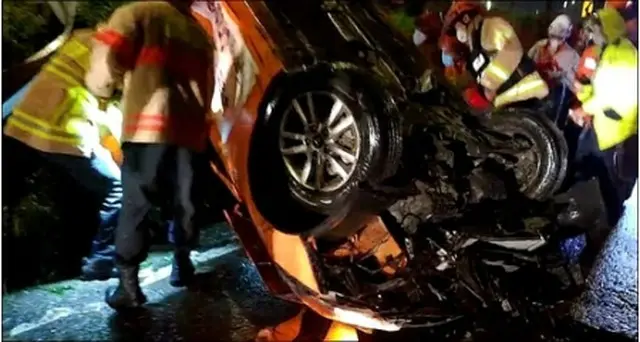 雨でスリップして横転したタクシー（江西消防署提供）＝（聯合ニュース）≪転載・転用禁止≫