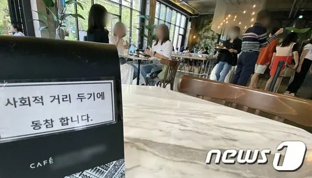 13日の韓国ソウル市内のカフェの様子。「ソーシャルディスタンスを守ろう」という看板が出されている（画像提供:wowkorea）