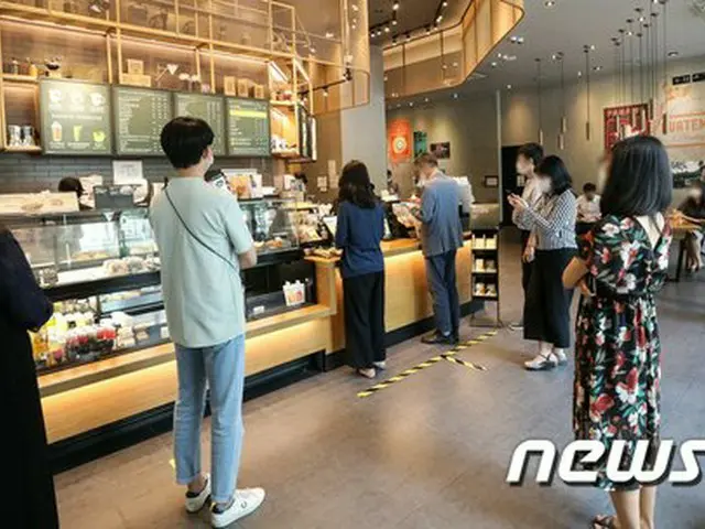ソウルの社会的距離の確保が2段階に緩和された14日、ソウル市内のあるフランチャイズコーヒー店で人々が注文するため並んでいる。（画像提供:wowkorea）