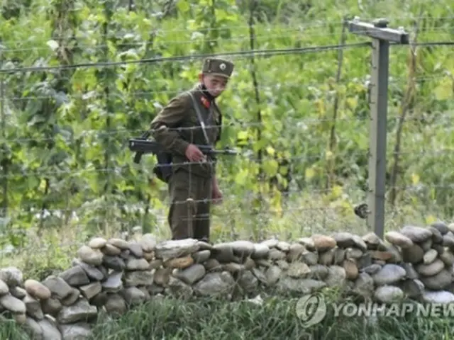 今月初め、中国・吉林省長白朝鮮族自治県から撮影した北朝鮮側。銃を持った朝鮮人民軍の兵士が鴨緑江沿いを警備している（資料写真）＝（共同＝聯合ニュース）