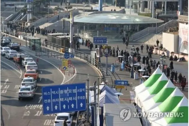 ソウル駅広場に設けられた新型コロナウイルスの臨時検査所を訪れた市民が、列を作って順番を待っている=２１日、ソウル（聯合ニュース）