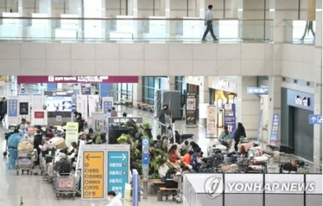 仁川国際空港の指定場所で待機する海外からの入国者＝２８日、仁川（聯合ニュース）