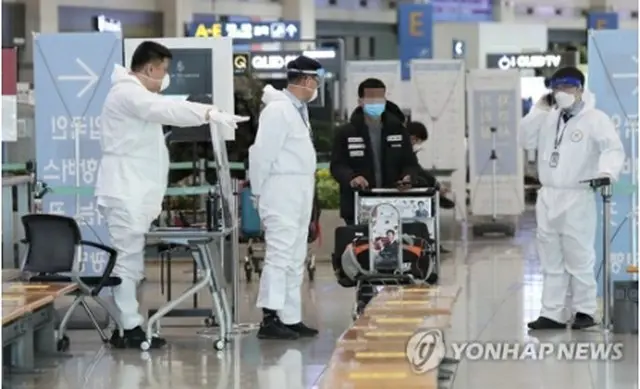 仁川国際空港で入国者を案内する職員＝28日、仁川（聯合ニュース）