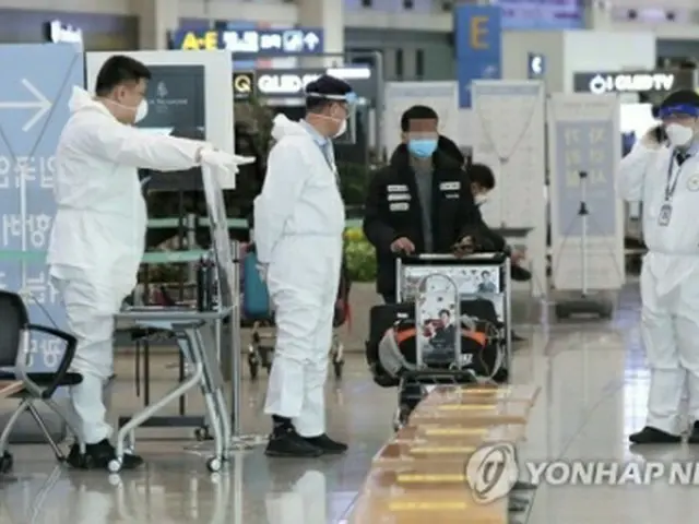 仁川国際空港で入国者を案内する職員＝28日、仁川（聯合ニュース）