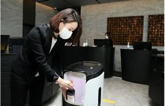Ｌ７江南が導入したデリバリーロボット。従業員が客室に届ける飲み物をロボットに入れている（提供）＝（聯合ニュース）≪転載・転用禁止≫