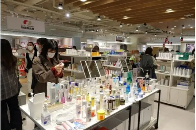 期間限定ショップで商品を手に取る女性（KOTRA提供）＝（聯合ニュース）≪転載・転用禁止≫