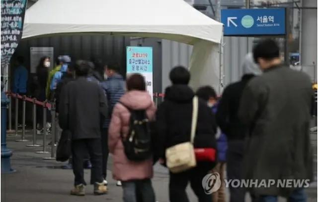 ソウル駅前に設置された臨時検査所で検査の順番を待つ市民ら＝２１日、ソウル（聯合ニュース）