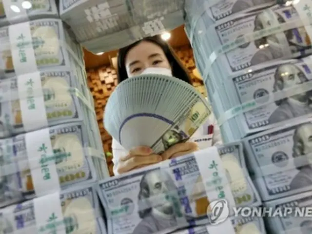 ソウルのハナ銀行本店で米ドル紙幣を数える行員＝（聯合ニュース）