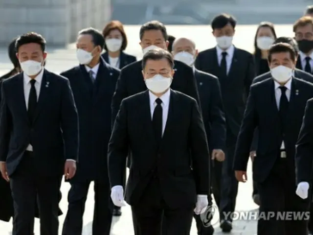 国立4・19民主墓地を参拝した文大統領（中央）＝19日、ソウル（聯合ニュース）