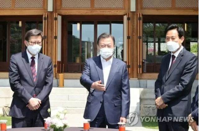 呉氏（右）、朴氏（左）と談笑する文大統領＝２１日、ソウル（聯合ニュース）