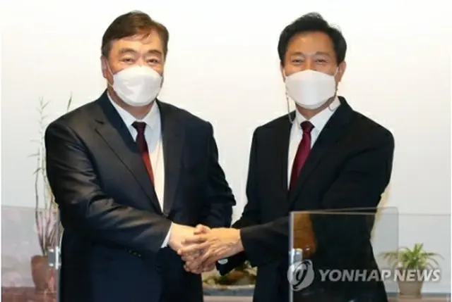 握手する呉世勲氏（右）とケイ海明氏＝２６日、ソウル（聯合ニュース）