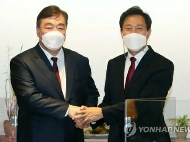 握手する呉世勲氏（右）とケイ海明氏＝２６日、ソウル（聯合ニュース）