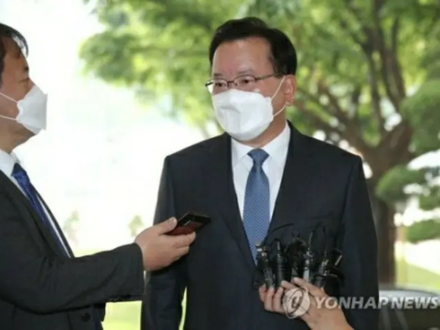 政府ソウル庁舎に到着した金富謙首相。報道陣の質問に答えている=14日、ソウル（聯合ニュース）