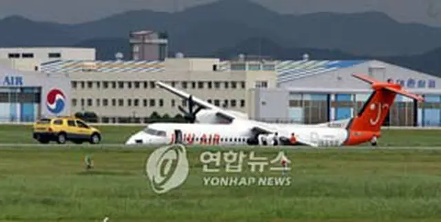 事故機と収拾に駆けつけた空港関係者＝12日、釜山（聯合）