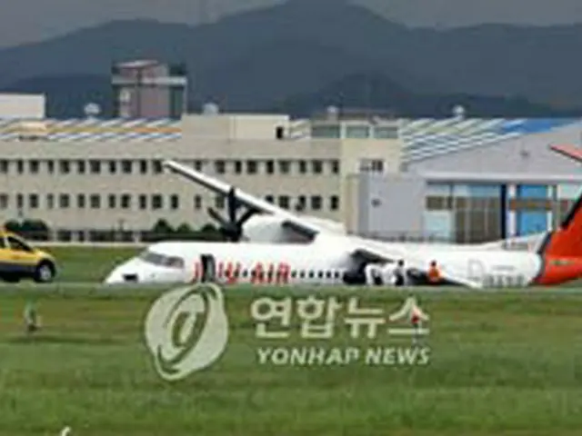 事故機と収拾に駆けつけた空港関係者＝12日、釜山（聯合）