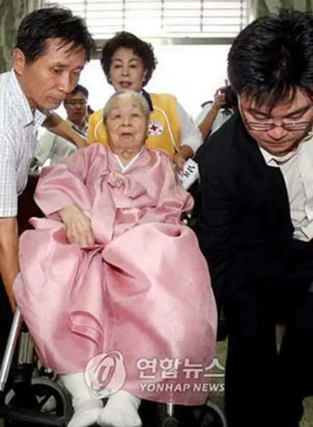 移動が不自由なため助けを借りながら面会会場に向かう101歳の参加者＝13日、ソウル（聯合）