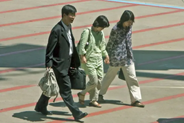 アフガニスタンでボランティア活動中に武装勢力に拉致され、このほど解放された韓国人女性2人が17日午後、帰国した。仁川空港を関係者とともに移動している＝17日、永宗島（聯合）