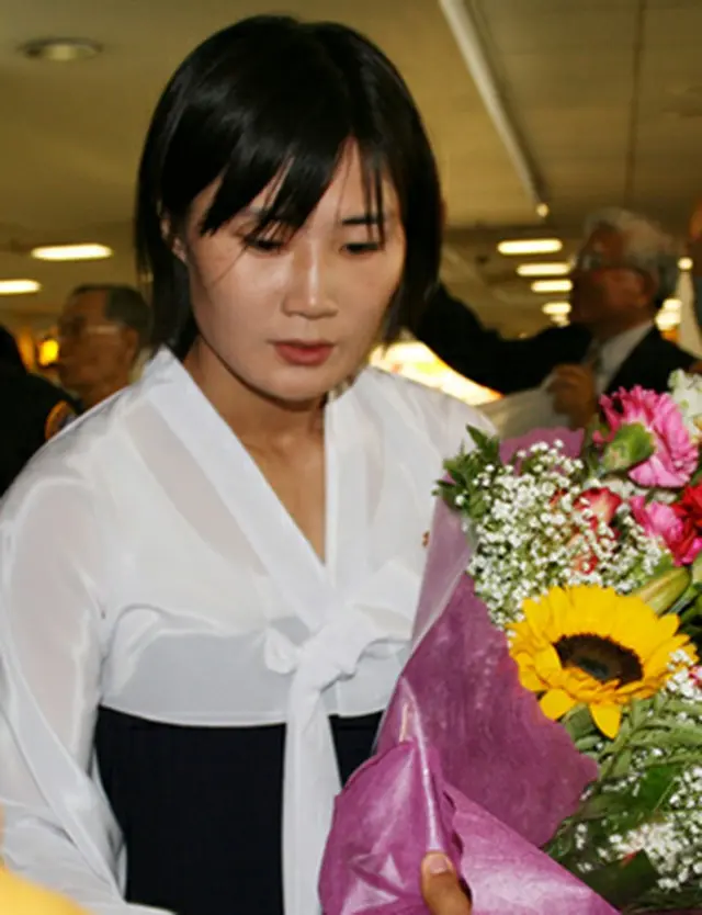 ロスの空港で花束を受け取る北朝鮮のテコンドー示範団＝4日、ロサンゼルス（聯合）