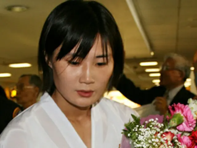 ロスの空港で花束を受け取る北朝鮮のテコンドー示範団＝4日、ロサンゼルス（聯合）