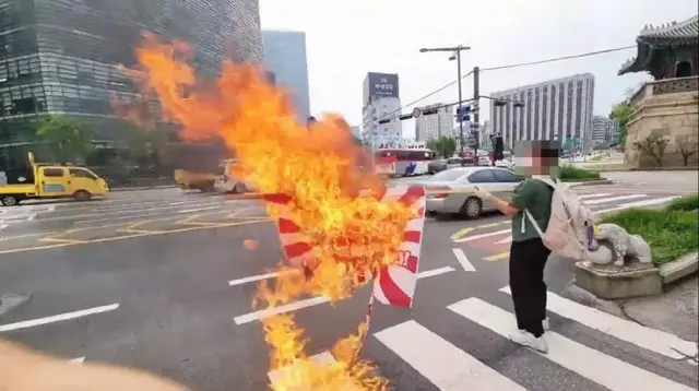 1日、ソウル鍾路区の在韓日本大使館の周辺で旭日旗を燃やすパフォーマンスをする大学生（画像提供:wowkorea）