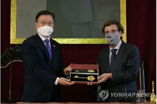 マドリード市庁を訪問した文大統領（左）。アルメイダ市長から黄金の鍵を贈られた＝１５日、マドリード（聯合ニュース）