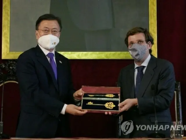 マドリード市庁を訪問した文大統領（左）。アルメイダ市長から黄金の鍵を贈られた＝１５日、マドリード（聯合ニュース）