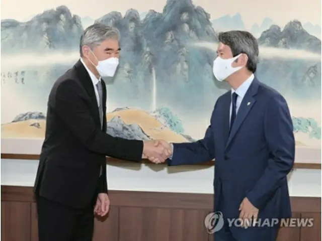 握手を交わす李仁栄・統一部長官（右）とソン・キム北朝鮮担当特別代表＝２２日、ソウル（聯合ニュース）