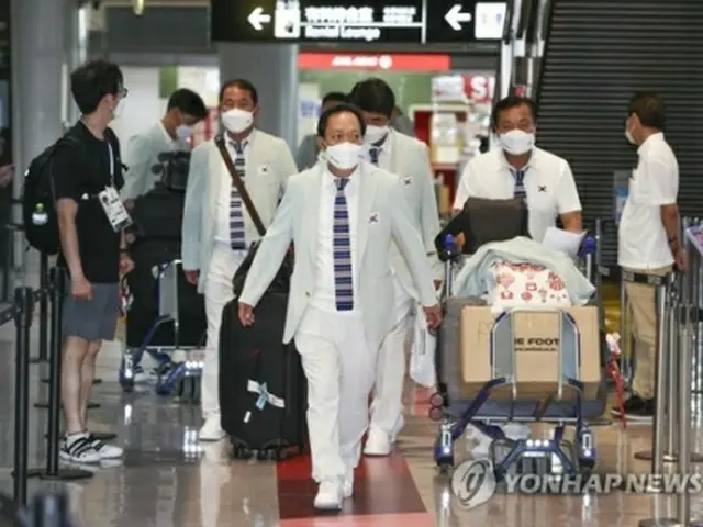 成田空港に到着した張仁華・選手団長（中央）＝１９日、成田（聯合ニュース）