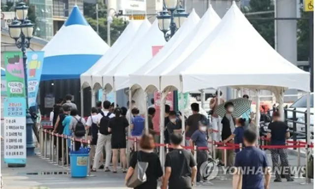 ソウル駅前に設置された新型コロナウイルスの検査所で順番を待つ人々＝２８日、ソウル（聯合ニュース）