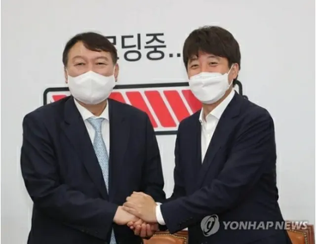 手を取り合う尹氏（左）と李代表＝２日、ソウル（聯合ニュース）