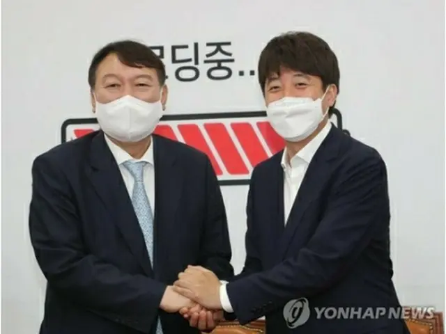 手を取り合う尹氏（左）と李代表＝２日、ソウル（聯合ニュース）