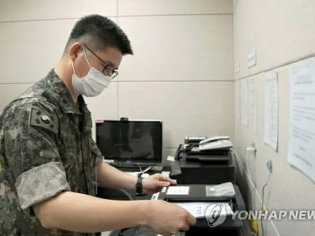 7月27日、韓国軍関係者が軍通信線を使って北朝鮮側にファックスを送っている（国防部提供）＝（聯合ニュース）≪転載・転用禁止≫
